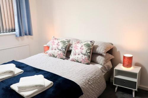 a bedroom with a bed with towels on it at Lovely staycation with family FREE Parking & WiFi in Beeston