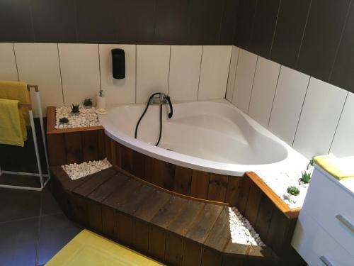 a large bath tub in a bathroom with a phone at Ti kaz Hoareau in Salazie