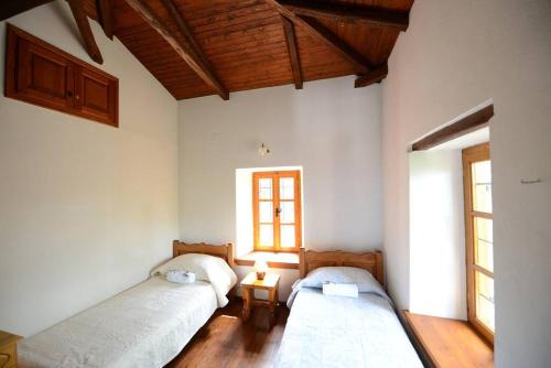 een slaapkamer met 2 bedden en een raam bij Aronia Stone House in Lafkos