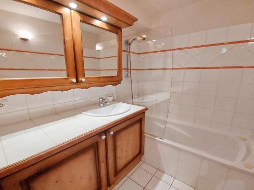 La salle de bains est pourvue d'un lavabo, d'une baignoire et d'un miroir. dans l'établissement Appartement Samoëns, 3 pièces, 6 personnes - FR-1-624-28, à Samoëns