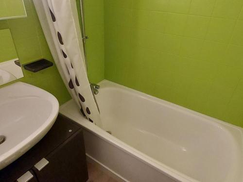 ein grünes Badezimmer mit einem Waschbecken und einer Badewanne in der Unterkunft Studio Samoëns, 1 pièce, 4 personnes - FR-1-624-56 in Samoëns