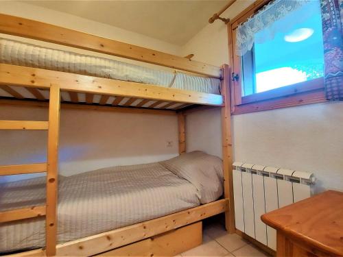 a bedroom with two bunk beds and a table at Appartement Samoëns, 2 pièces, 4 personnes - FR-1-624-61 in Samoëns