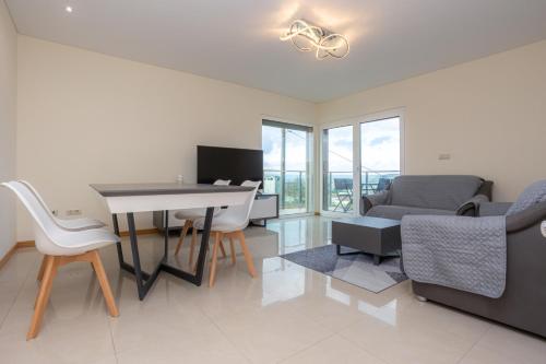a living room with a table and chairs and a couch at Buarcos Sunset Apartment by Rent4All in Figueira da Foz