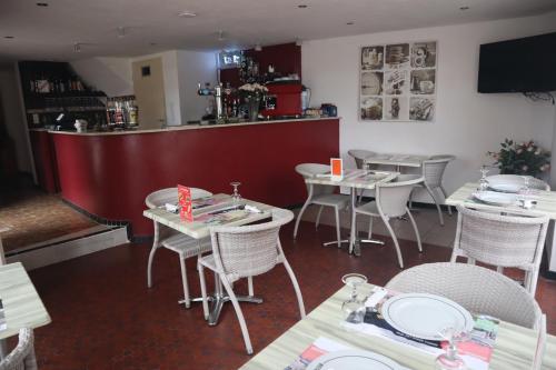 un restaurante con mesas y sillas y un bar en Le Bellerive, en Peyrat-le-Château
