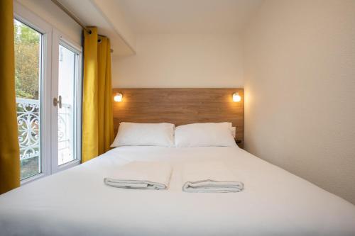 ein Schlafzimmer mit einem Bett mit zwei Handtüchern darauf in der Unterkunft Les Arènes Idéal en Famille ou entre Amis in Périgueux