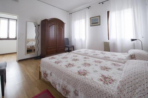 a bedroom with two beds and a chair and a window at Casa Sincielli in Caorle