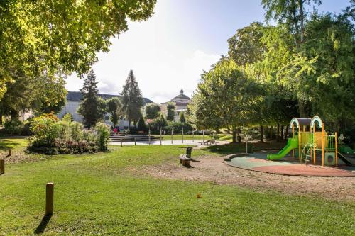 einen Park mit Spielplatz mit Rutsche in der Unterkunft Les Arènes Idéal en Famille ou entre Amis in Périgueux