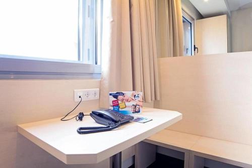 a telephone on a white counter in a room at Park Hotel Porto Valongo in Valongo