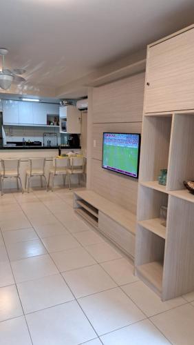 un soggiorno con una TV a schermo piatto su una parete di Guarajuba Paraíso a Camaçari