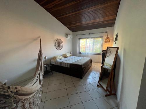 ein Schlafzimmer mit einem Bett und einer Hängematte in einem Zimmer in der Unterkunft Casa Pirambu in Pipa