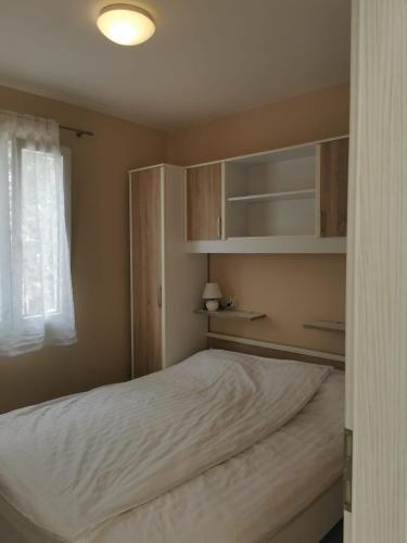 a bedroom with a bed and shelves and a window at Holiday House Rasopasno in Rasopasno