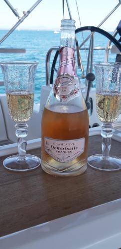 une bouteille de whisky assise sur une table avec deux verres dans l'établissement Location studio Grau du Roi Mas des Marines Piscine, au Grau-du-Roi