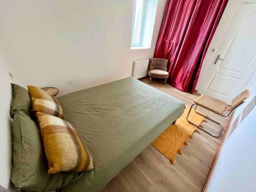 1 dormitorio con cama verde y cortina roja en Bel appartement, proche plages pour 4 personnes, 2 chambres en Clohars-Carnoët