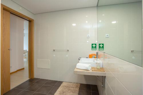 a bathroom with a sink and a glass shower at Galante Beach Apartment II in Figueira da Foz