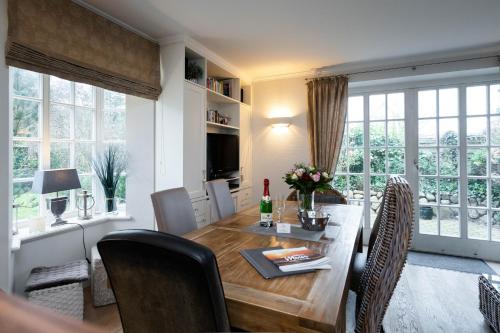 a dining room and living room with a table and chairs at Hermes Hü in Wenningstedt