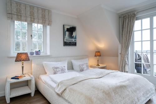 - une chambre avec un lit blanc et 2 fenêtres dans l'établissement Hermes Hü, à Wenningstedt