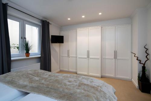 a bedroom with white cabinets and a window at Hermes Hü in Wenningstedt