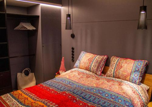 ein Schlafzimmer mit einem Bett mit bunten Decken und Kissen in der Unterkunft TINY 4 YOU - Ihre stilvollen TINY-Häuser am Bodensee in Hörbranz