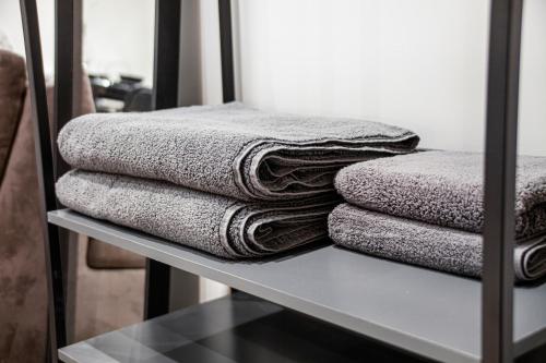 a pile of towels sitting on a shelf at Modern Luxury Studios London in London