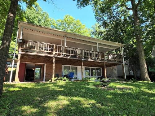 a large house with a balcony on top of a yard at Lake Malone ky Lake shore home right on water with private boat dock, A Shore Thing in Lewisburg