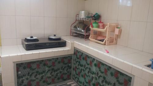 a kitchen with a stove and a counter top at HOMESTAY PARAK KAYU in Baso