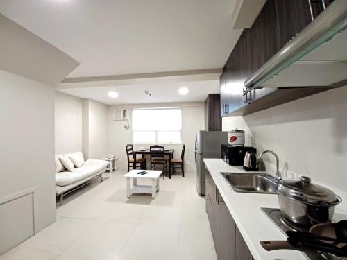 a kitchen with a couch and a table in a room at Gilmore Tower Suites By SMS Hospitality in Quezon City