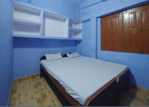 um pequeno quarto azul com uma cama em Krishna Guest House By WB Inn em Agra