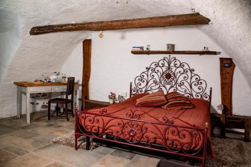 a bedroom with a red bed with a desk and a table at Agribenessere Agli Abatti in Barge