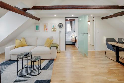 a living room with a white couch and a table at St Georgen-Strasse Studios by VISIMO - Design, City, Nature in St. Gallen