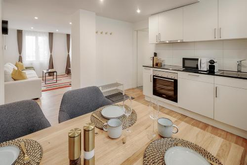a kitchen and living room with a table and chairs at St Georgen-Strasse Studios by VISIMO - Design, City, Nature in St. Gallen