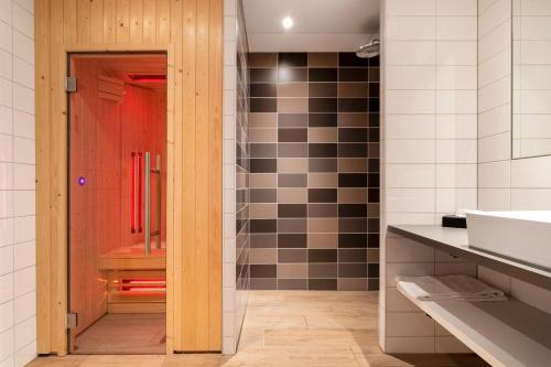 a bathroom with a sink and a red door at U Parkhotel in Enschede