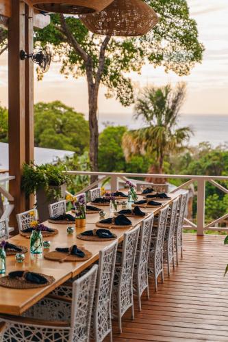 a long table with chairs on a deck at Blue Roatan Resort in West Bay