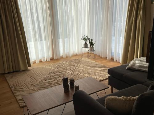 a living room with a couch and a coffee table at Waidlerland Waldkirchen Chalets in Waldkirchen
