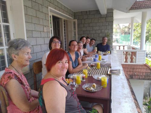 Un gruppo di persone sedute a tavola che mangiano di Hebron Inn a Cochin