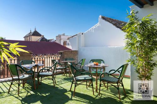 un patio con mesas y sillas en el césped en Casa Catedral, en Sevilla