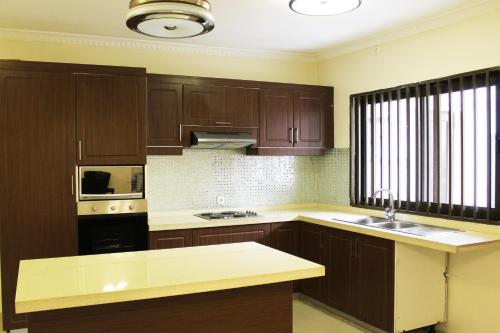 a kitchen with wooden cabinets and a counter top at Matola View Residence in Matola