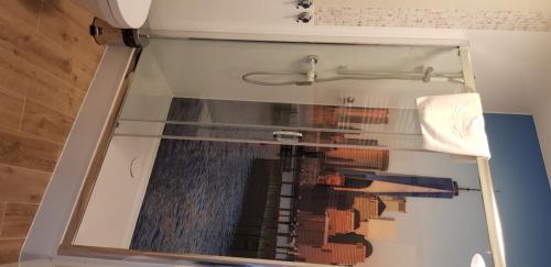 a shower with a glass door in a bathroom at Metropolis Apartamenty Centrum in Kalisz