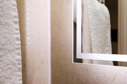 a mirror on a wall next to a towel at The Windermere Hotel, London in London