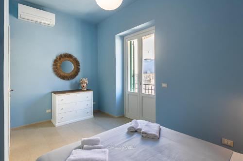 a blue bedroom with a bed and a mirror at House&Villas - Terrazza di Erika in Noto