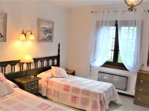 1 dormitorio con 2 camas y ventana en Villa Anna, en Begur