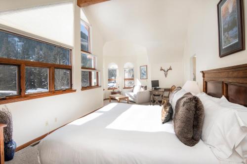 a bedroom with a large white bed and windows at 4551 Streamside Cir WEST HOUSE in Vail
