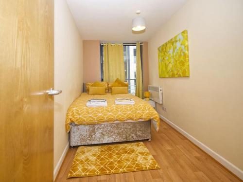 a small bedroom with a bed with a yellow bedspread at Alluring 2 Bedroom Leeds City Centre Apartment- Self Check-in,Balconied Apartment in Leeds