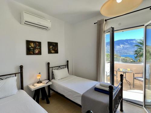 1 dormitorio con 2 camas y balcón en Villa Eros Spartia Kefalonia en Spartia