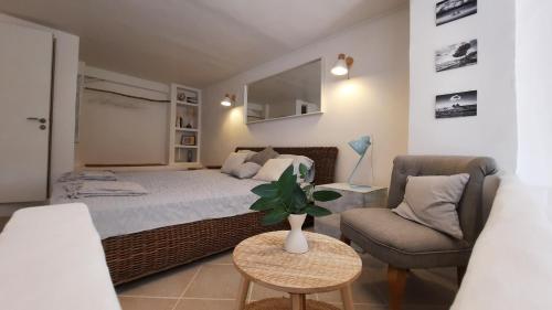 een slaapkamer met een bed, een bank en een stoel bij Les Bois Flottés . Plage de la Verne in La Seyne-sur-Mer