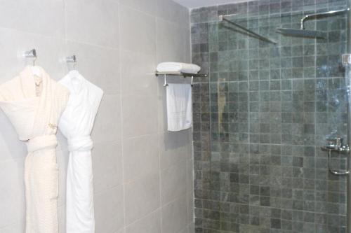 a bathroom with a shower with white clothes on racks at Dakhla Boarding Hotel & Restaurant in Dakhla