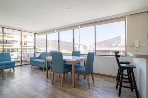 a dining room with a table and chairs and windows at Apartamento 2 habitaciones junto al mar! in Gaira