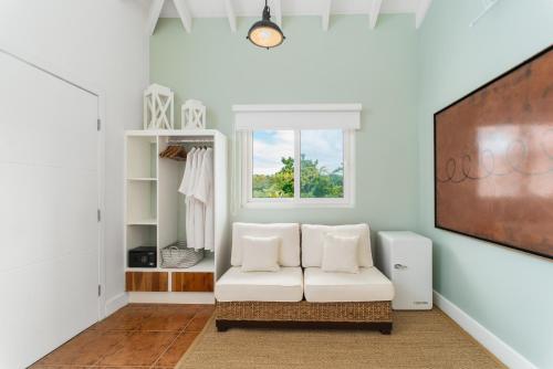 a living room with a white couch and a window at Blue Roatan Resort in West Bay