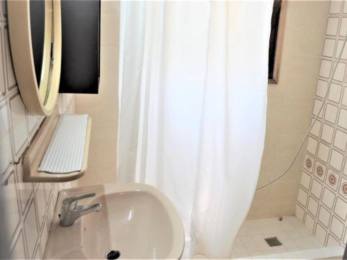 uma casa de banho com um lavatório e uma cortina de chuveiro branca em Casa Dynaida em Begur