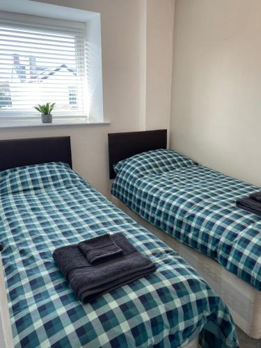 two beds sitting next to each other in a room at Foxy cottage nr Westward Ho! in Northam