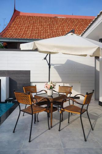 a table and chairs with an umbrella on a patio at *City~house* 芭堤雅豪华泳池别墅近步行街 in Pattaya South